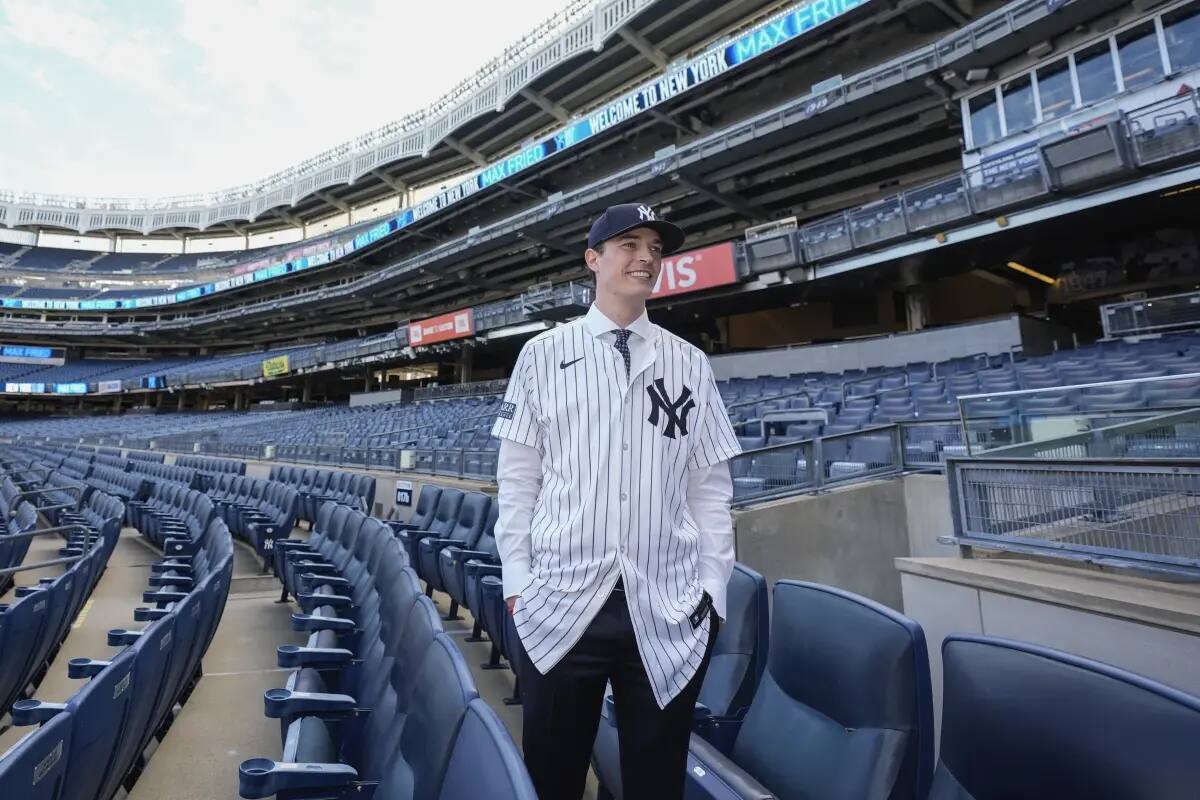 New York Yankees’ Max Fried smiles while posing for photographs following a baseball news conference, Wednesday, Dec. 18, 2024, in New York.
